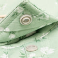 Close up snap collar button on green floral shirt