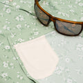 Sunglasses and hidden cleaner fabric on green western shirt