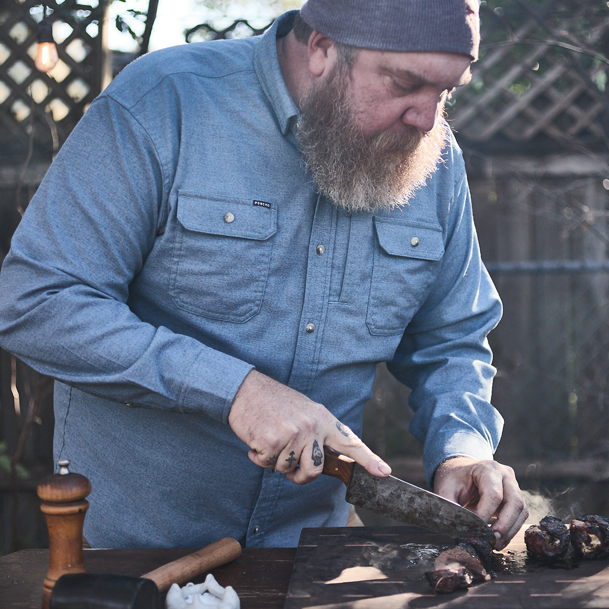 man cooking blue flannel button down