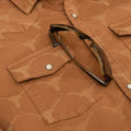 Sunglasses in chest pocket of orange longhorn denim shirt