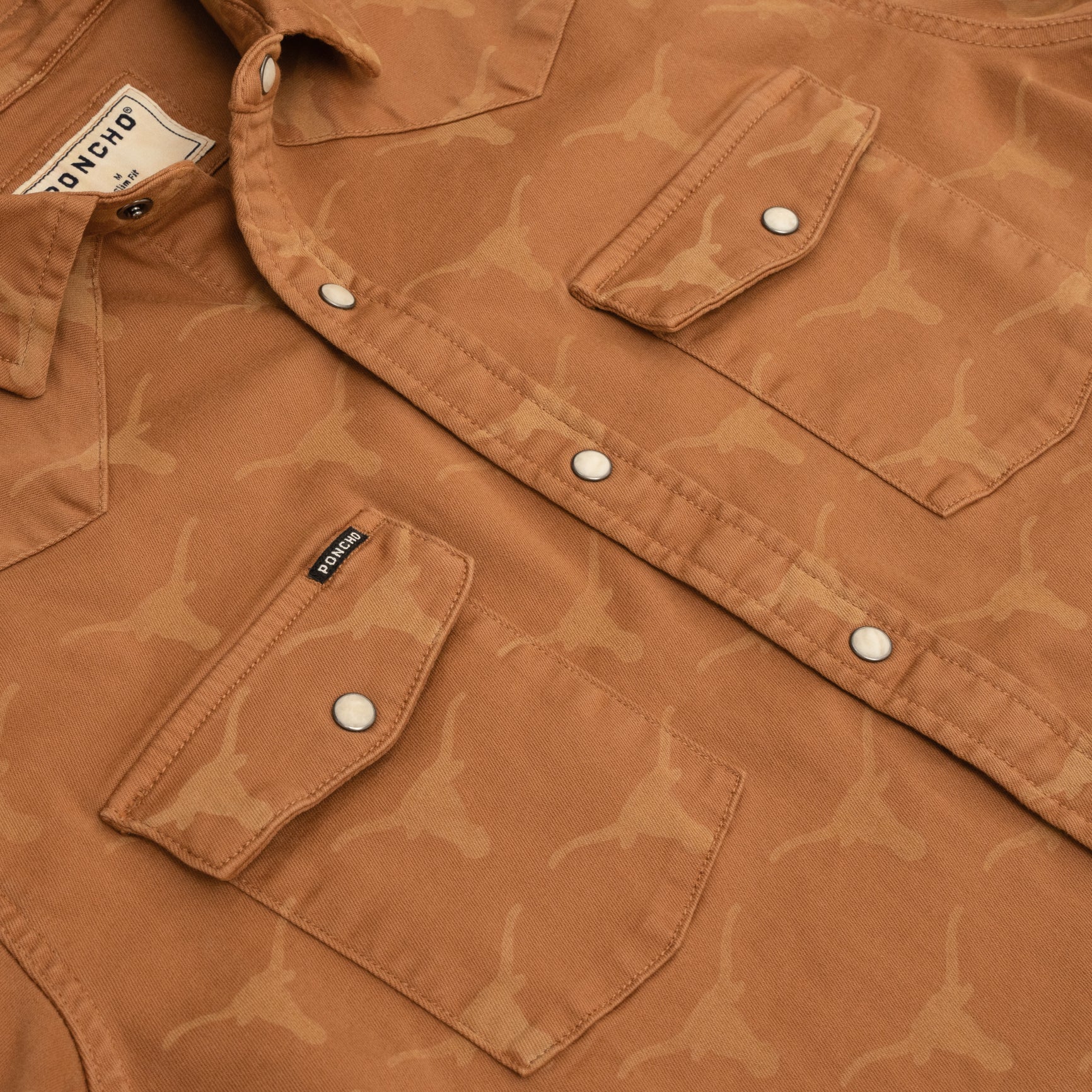 Close up photo of orange western denim shirt with Longhorn logo laser printed on it