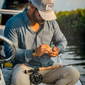 Man rigging fly rod in a boat