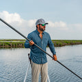 man poling a fishing skiff on the texas coast