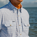 close up of man on a boat wearing a white button down with chest zippered pocket