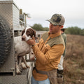 man with dog in brown and green shirt