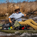 Man paddling in kayak wearing blue button down long sleeve short