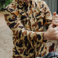 Guy holding decoys in camo western flannel shirt