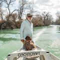 man driving boat wearing green microgrid button down shirt