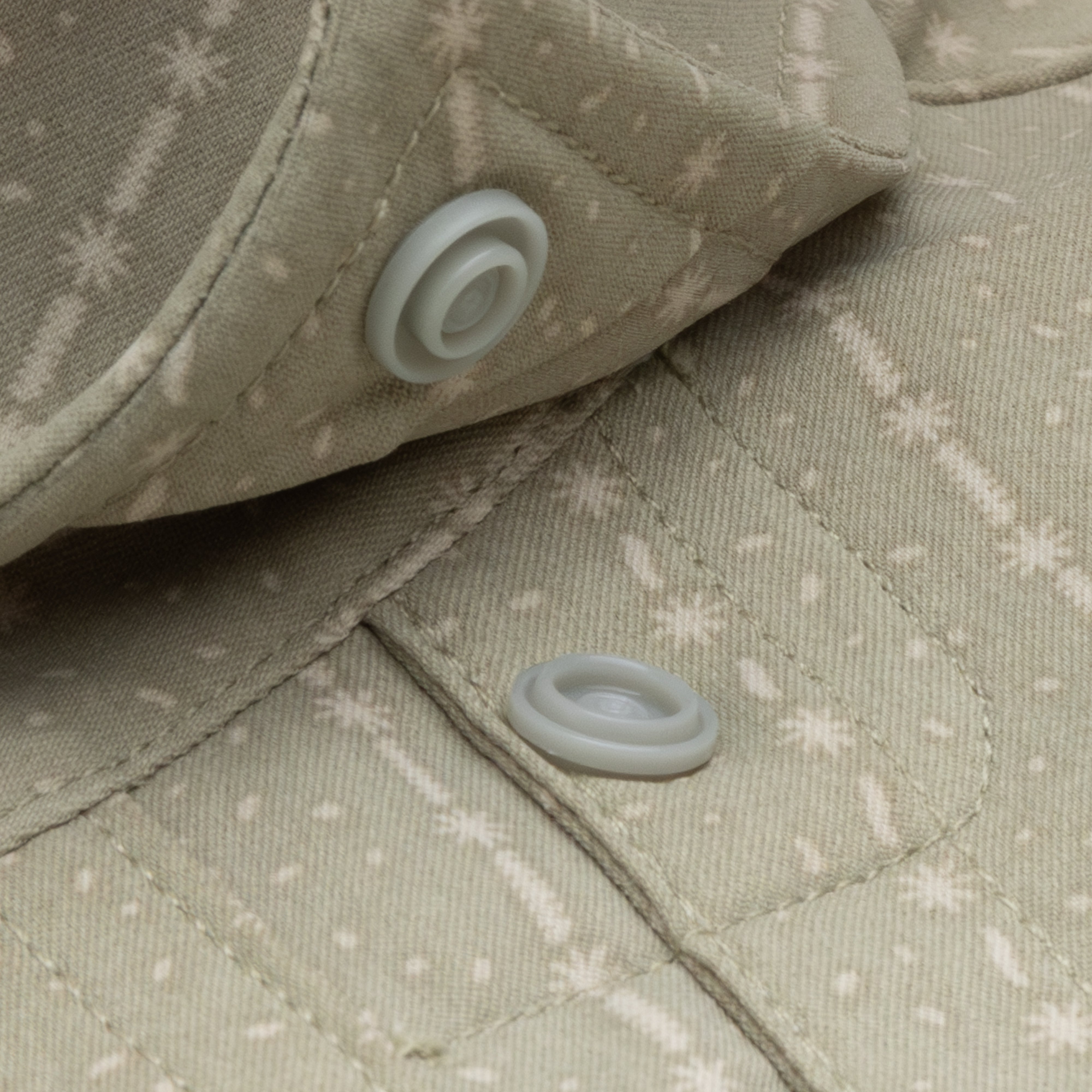 close up of collar snap buttons on green shirt with stars and stripes