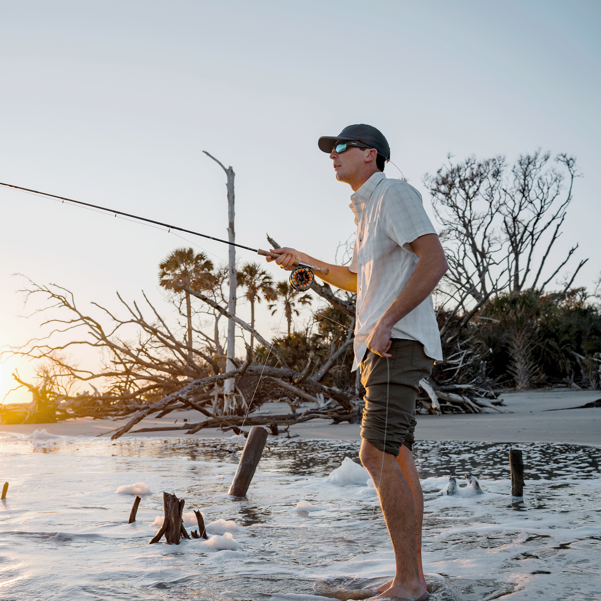 man wearing green and white plaid button down while fishing