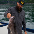 man holding fish in black flannel shirt