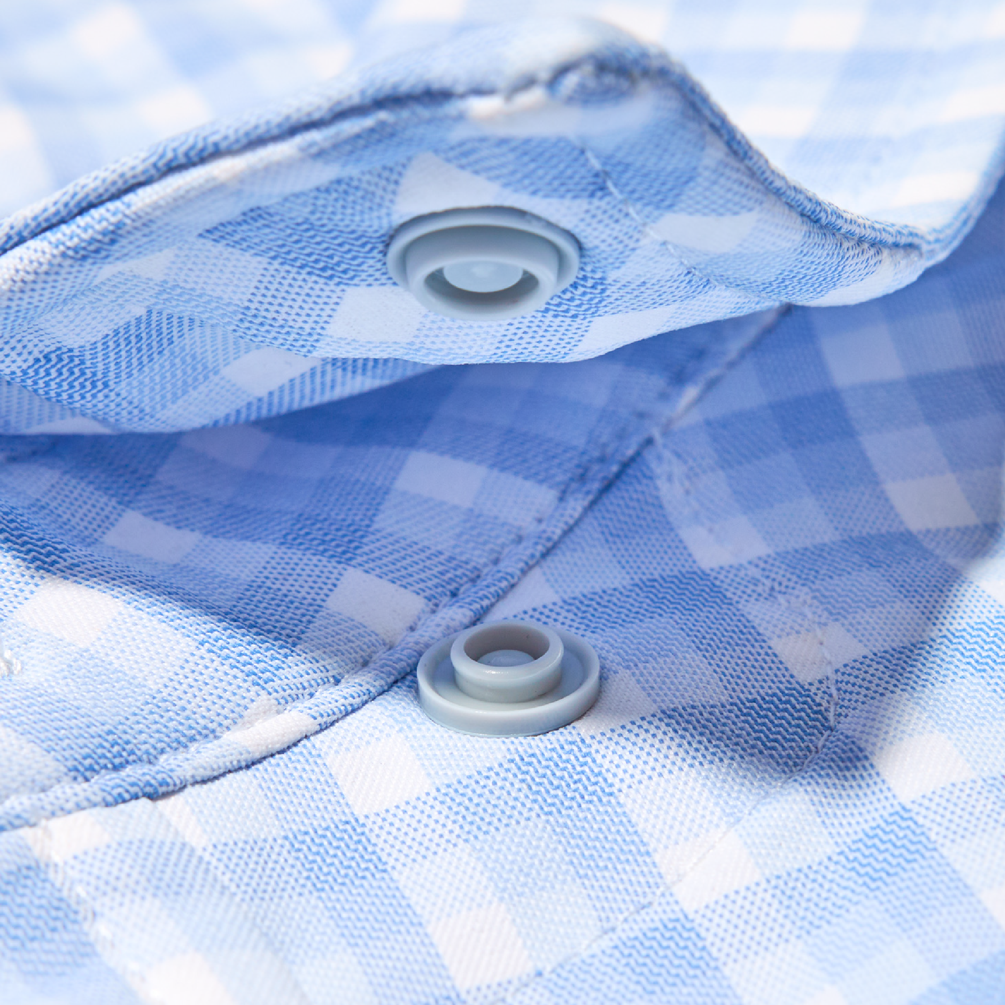 snap button on collar of blue plaid shirt