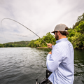 man catching fish in blue plaid long sleeve