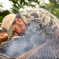 man starting fire in camo button up shirt