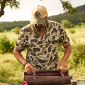 man rolling up bag in a field