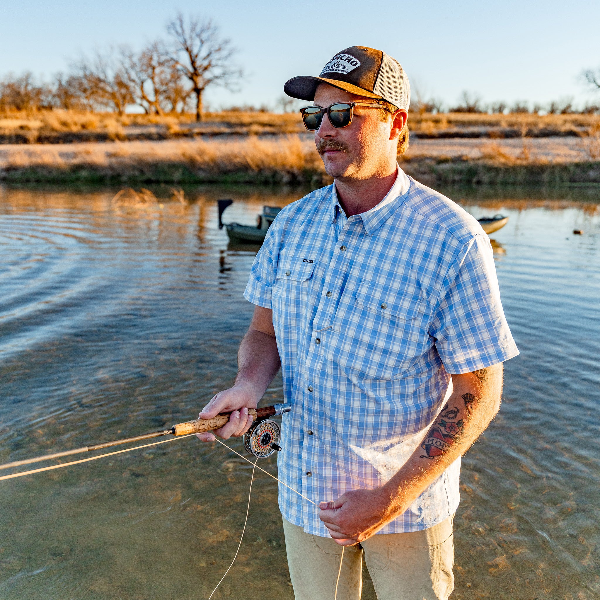 Man fishing in blue button down short sleeve shirt