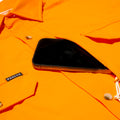 phone in chest pocket of bright orange shirt