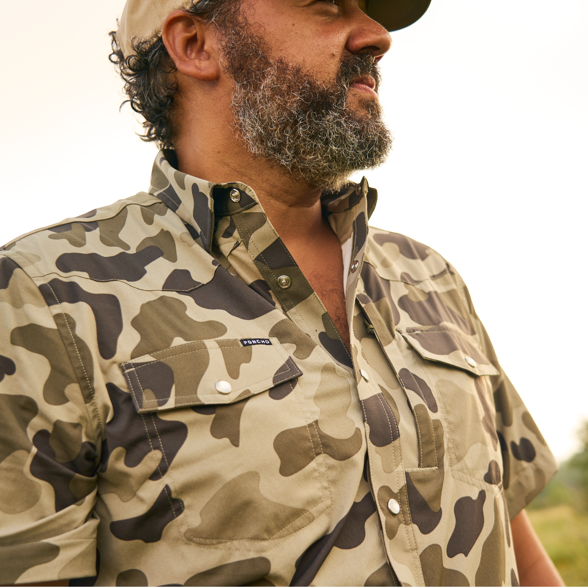 Close up of man wearing western camo pearl snap shirt