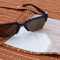 Close up of sunglasses on red shirt with lens cloth