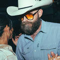 guy dancing with a girl in a bar in a pearl snap shirt and cowboy hat