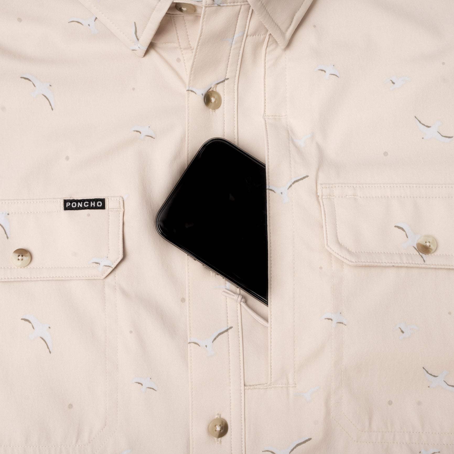 phone in hidden pocket of seagull print button up fishing shirt