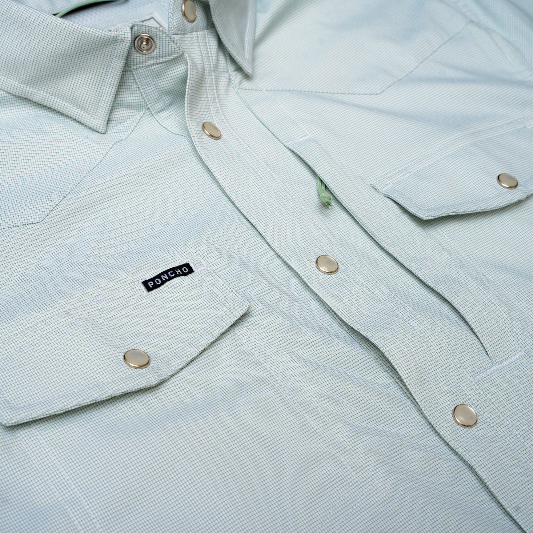 Close up of micro grid green pearl snap shirt