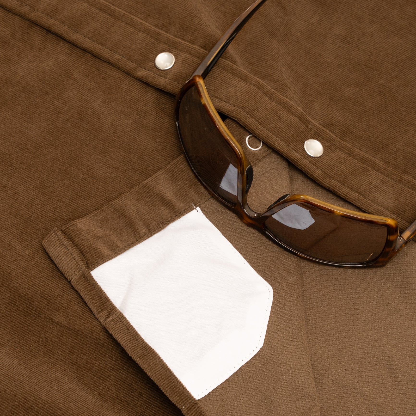 close up photo of brown corduroy western shirt sunglass cleaner cloth on inside of shirt