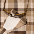 Sunglasses laying on hidden sunglass cleaner of brown flannel