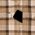 Phone in chest pocket of brown plaid flannel