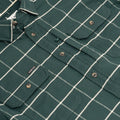 Close up photo of chest pocket and buttons on green plaid flannel