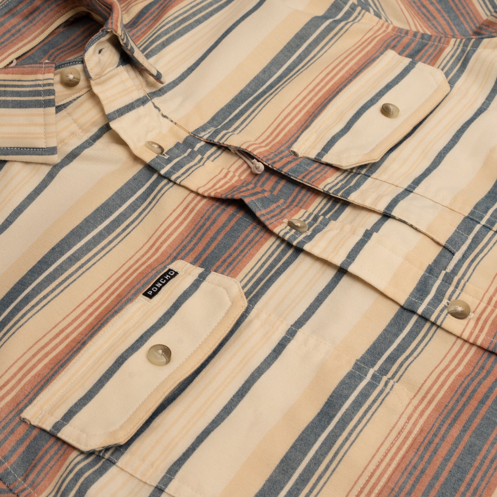 Close up of chest pockets and buttons on orange and yellow striped flannel shirt