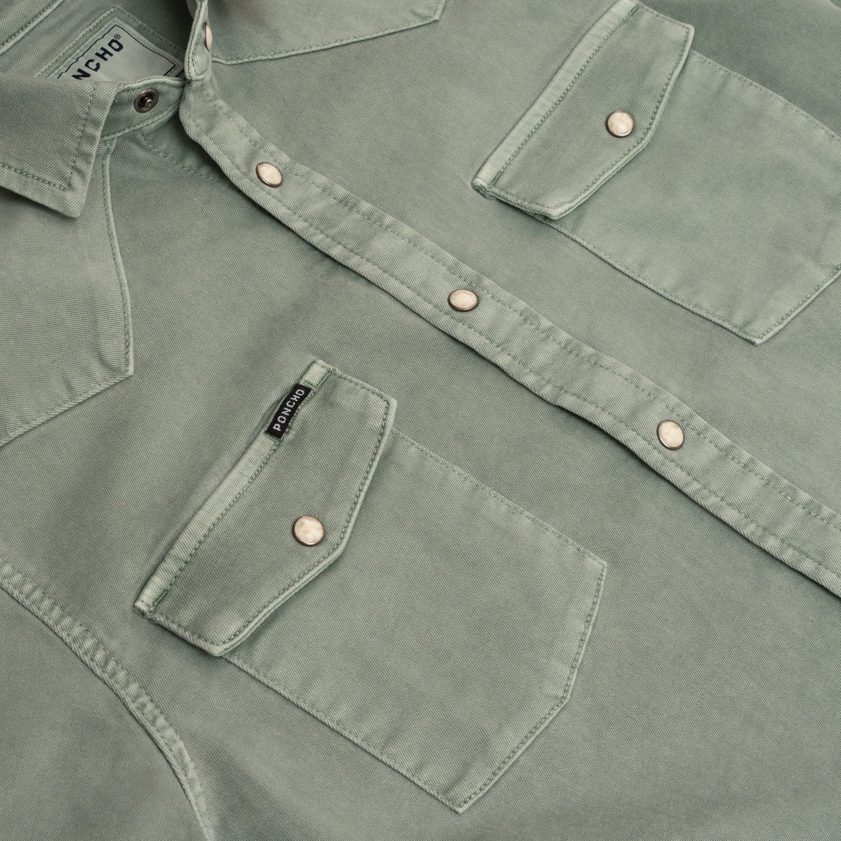 Close up of buttons on green denim shirt