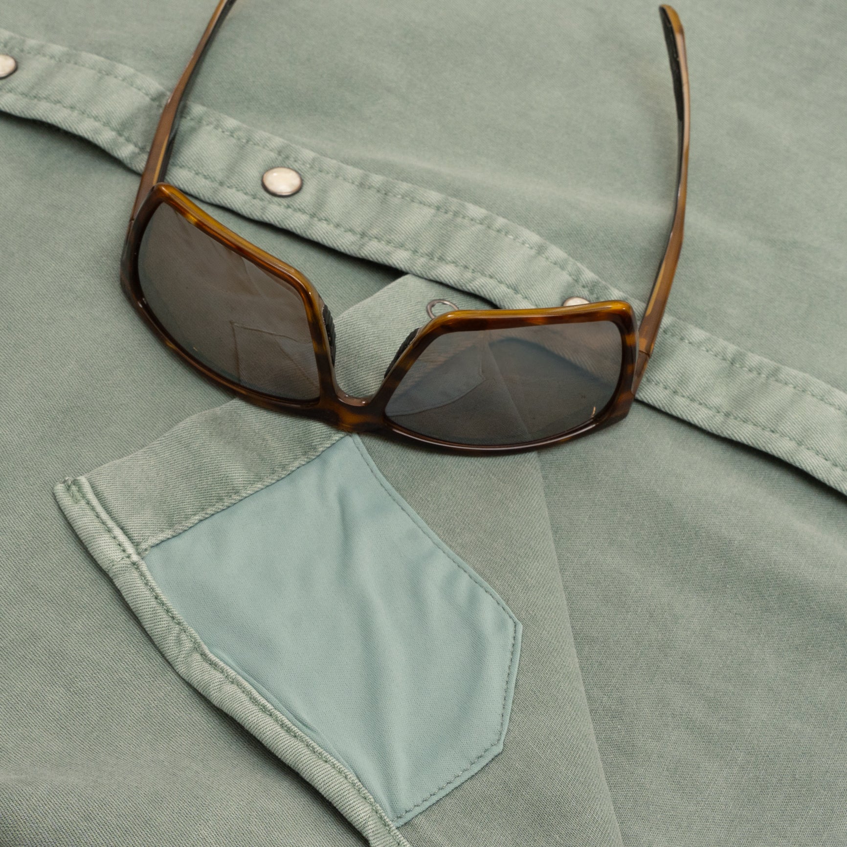 Sunglass cleaner fabric on green denim shirt