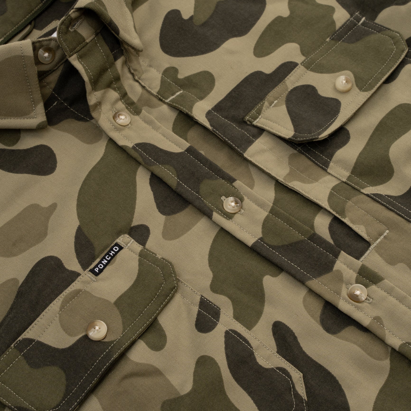 close up photo of chest pocket on dark camo flannel button down