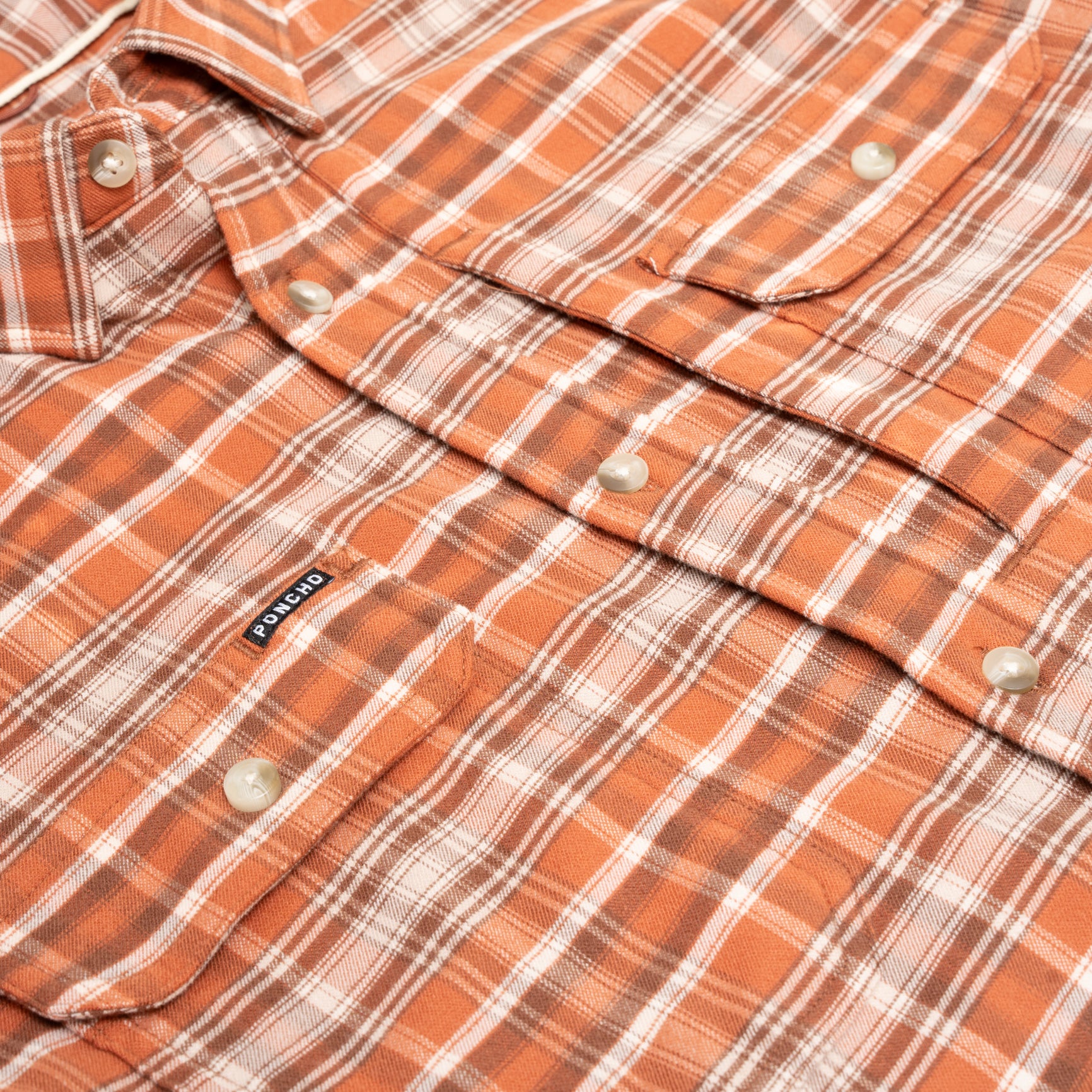 Close up photo of orange plaid flannel shirt