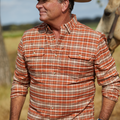 man wearing a orange plaid flannel with a horse in the background