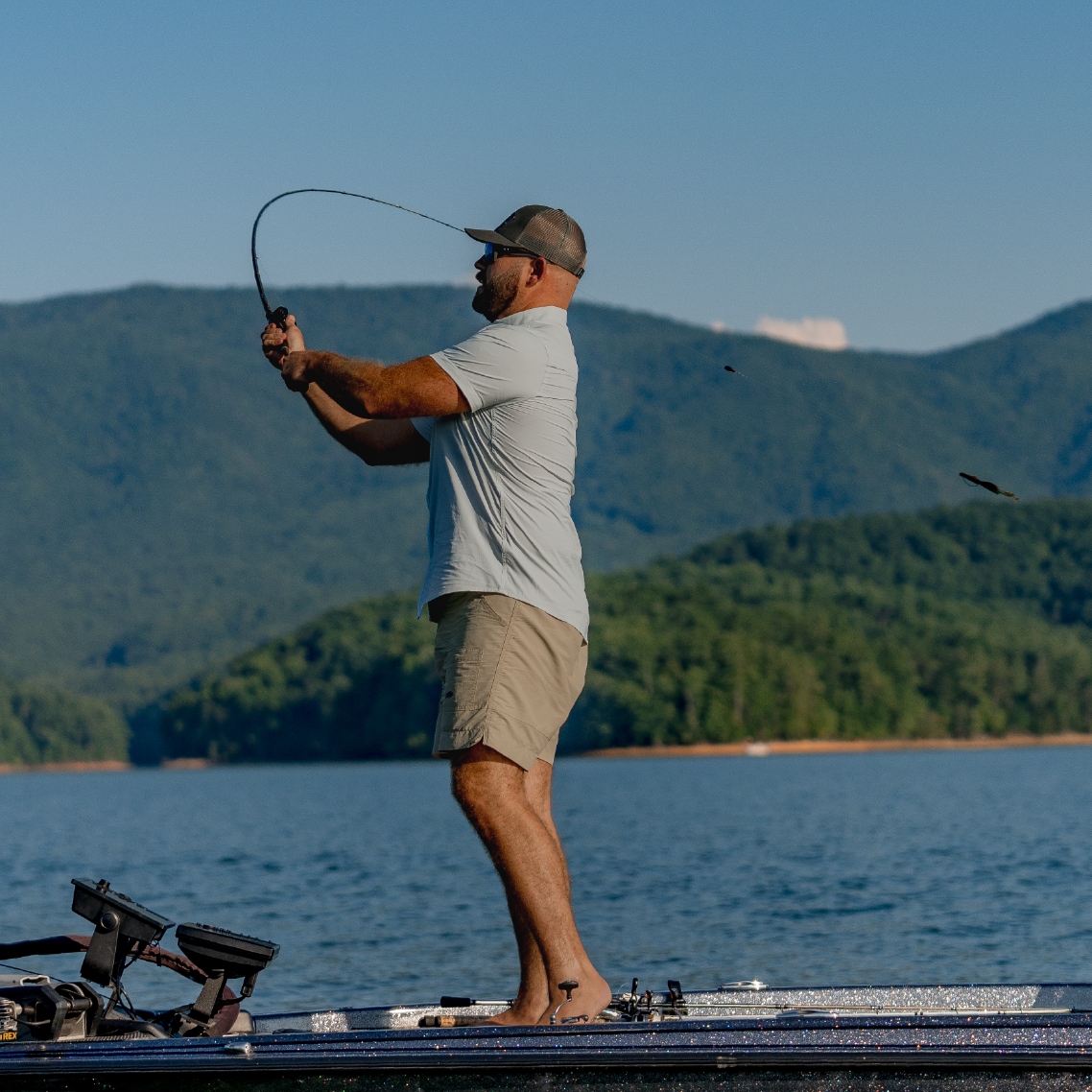 Man casting a carolina rig fishing lure while wearing a short sleeve button down