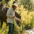 man leading horse to water in green shirt