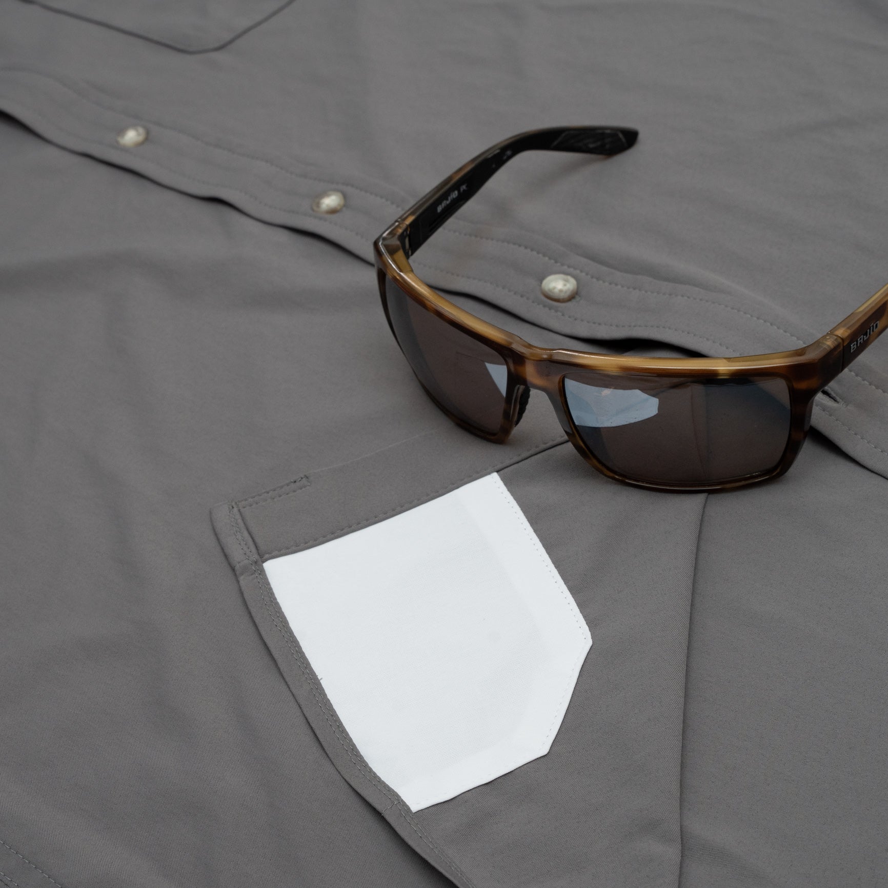 Sunglasses on shirt with hidden sunglass cleaner fabric