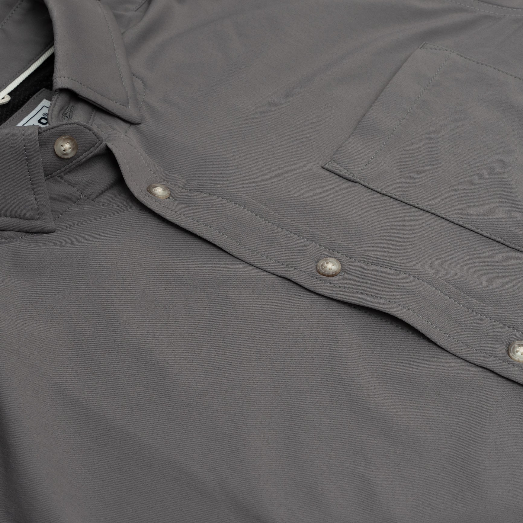 close up product photo of buttons and pockets on grey button down shirt