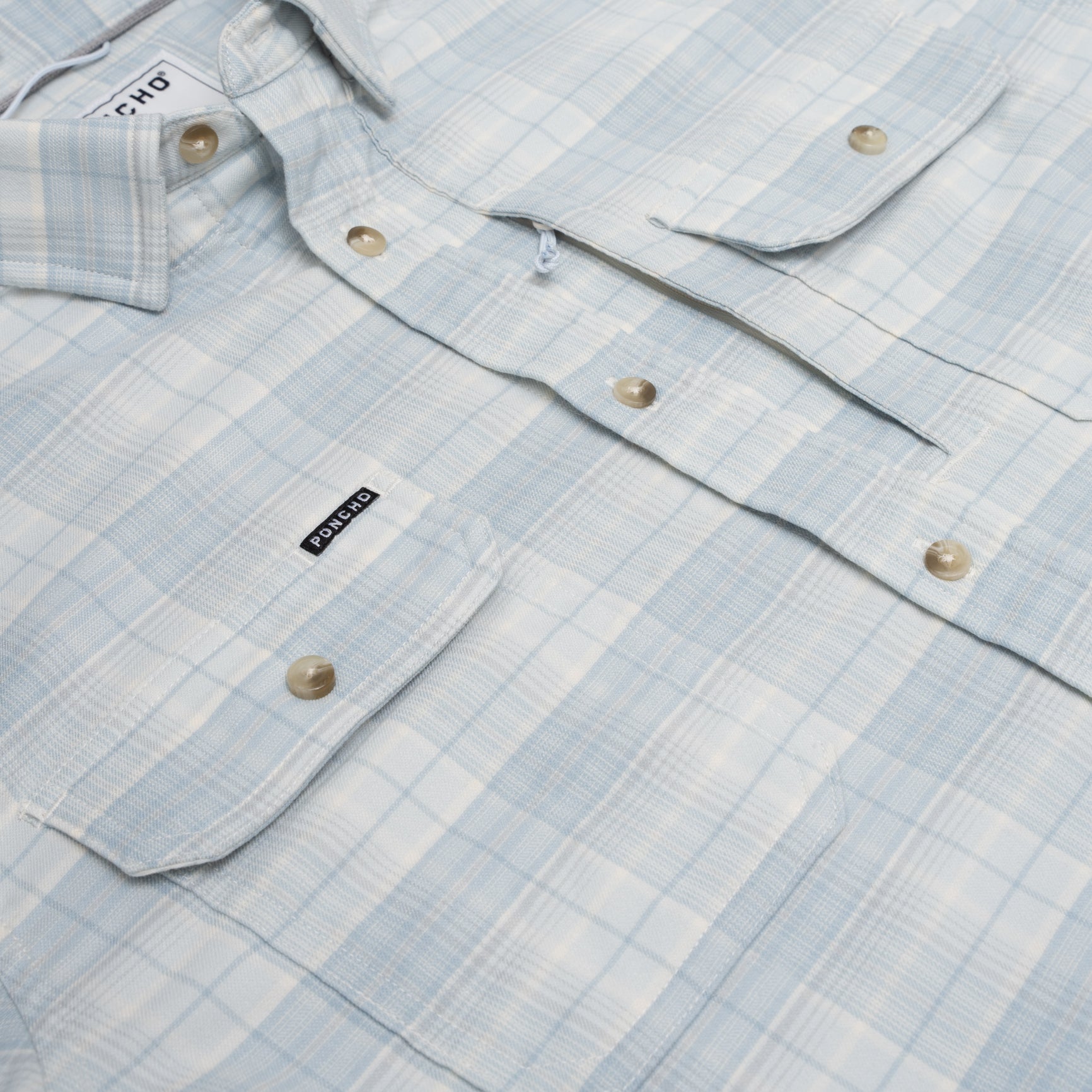 Close up photo of blue plaid flannel shirt with button pockets