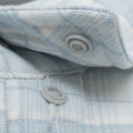 close up of snap buttons on blue plaid flannel shirt