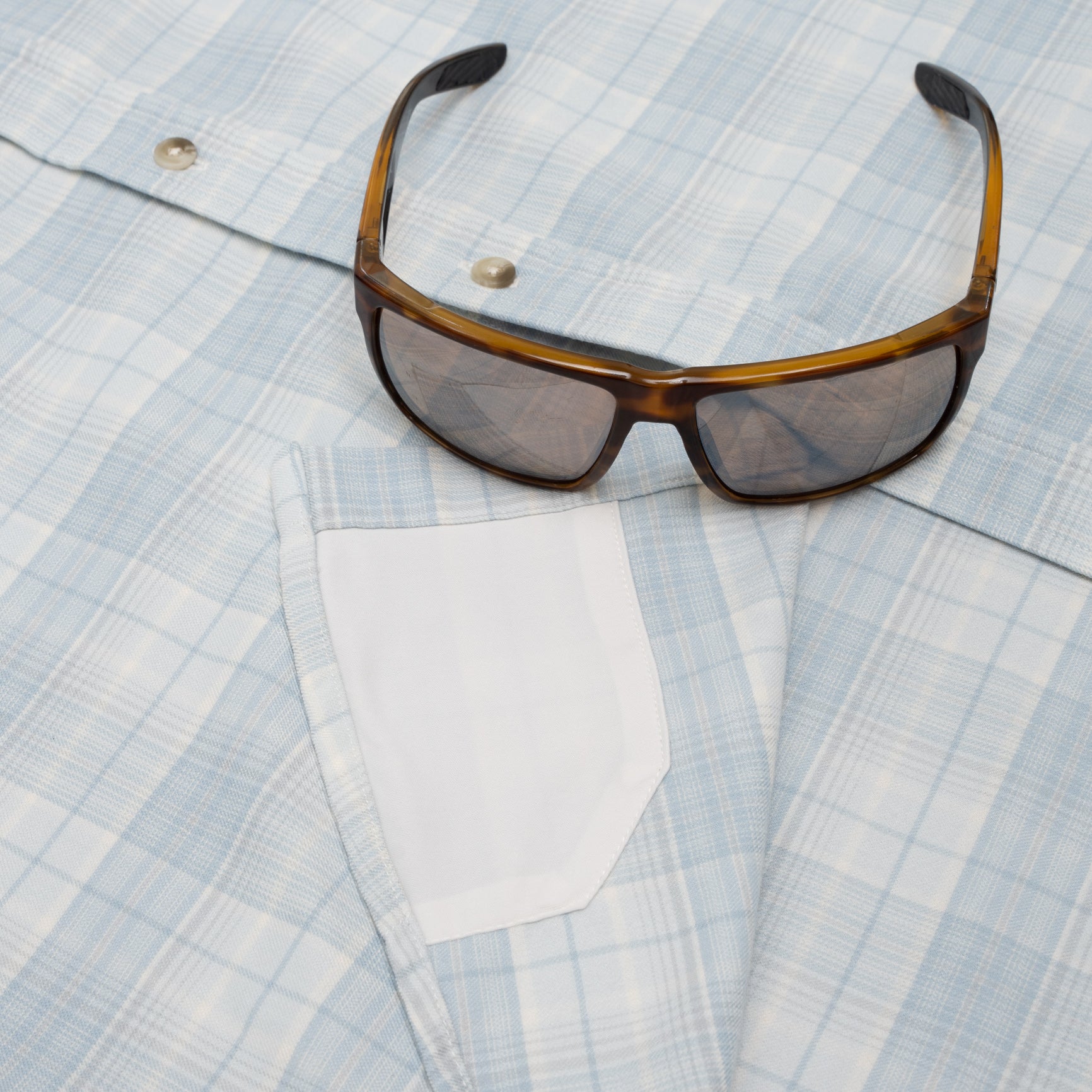 sunglasses on blue flannel shirt with sunglass cleaner fabric