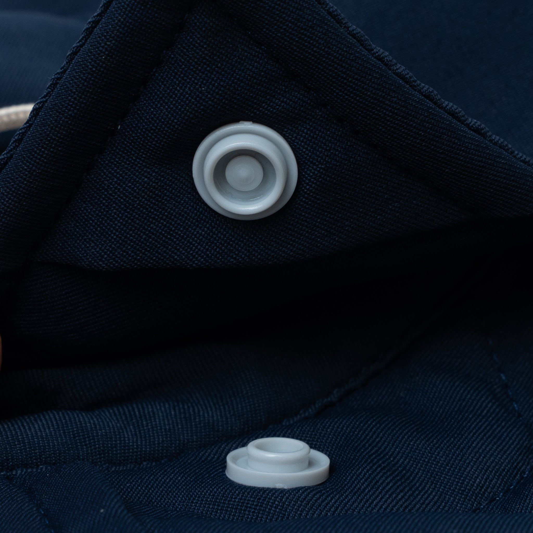 Hidden button snaps on the navy shirt collar