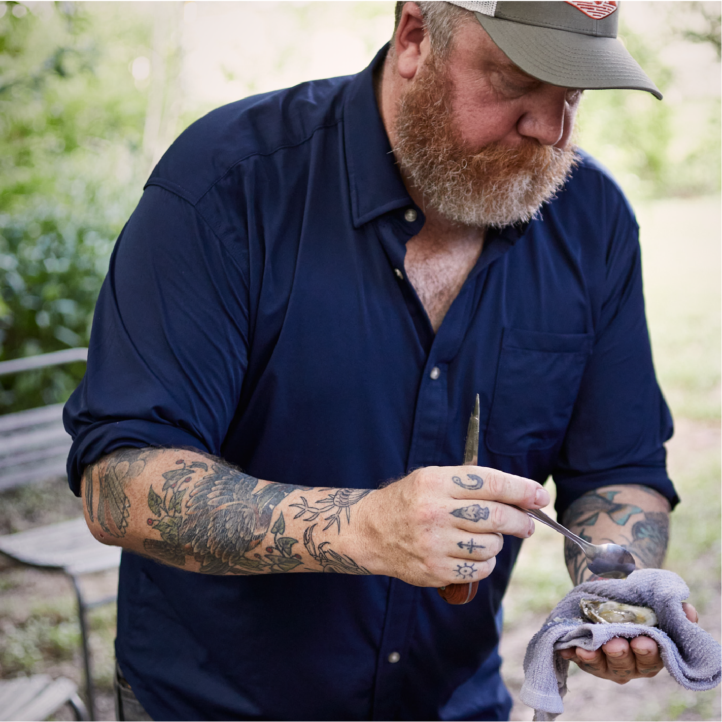 Man cooking oysters in navy long sleeve shirt