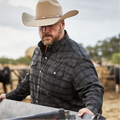 Man working with four wheeler on ranch in black plaid flannel pearl snap