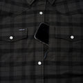 Phone in hidden chest zippered pocket of pearl snap flannel shirt