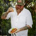 Man squeezing lime on meal while wearing solid white long sleeve button down