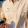 Man wearing seagull pearl snap with drink in his hand