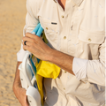 man on beach carrying a chair wearing the seagull long sleeve shirt